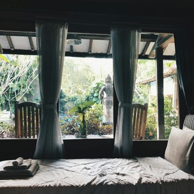 Relaxing bedroom overlooking lush garden in Marga, Bali. Serenity and comfort in a serene setting.